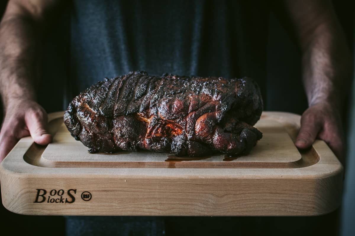 Man holding Bourbon Brown Sugar Pork on cutting board 