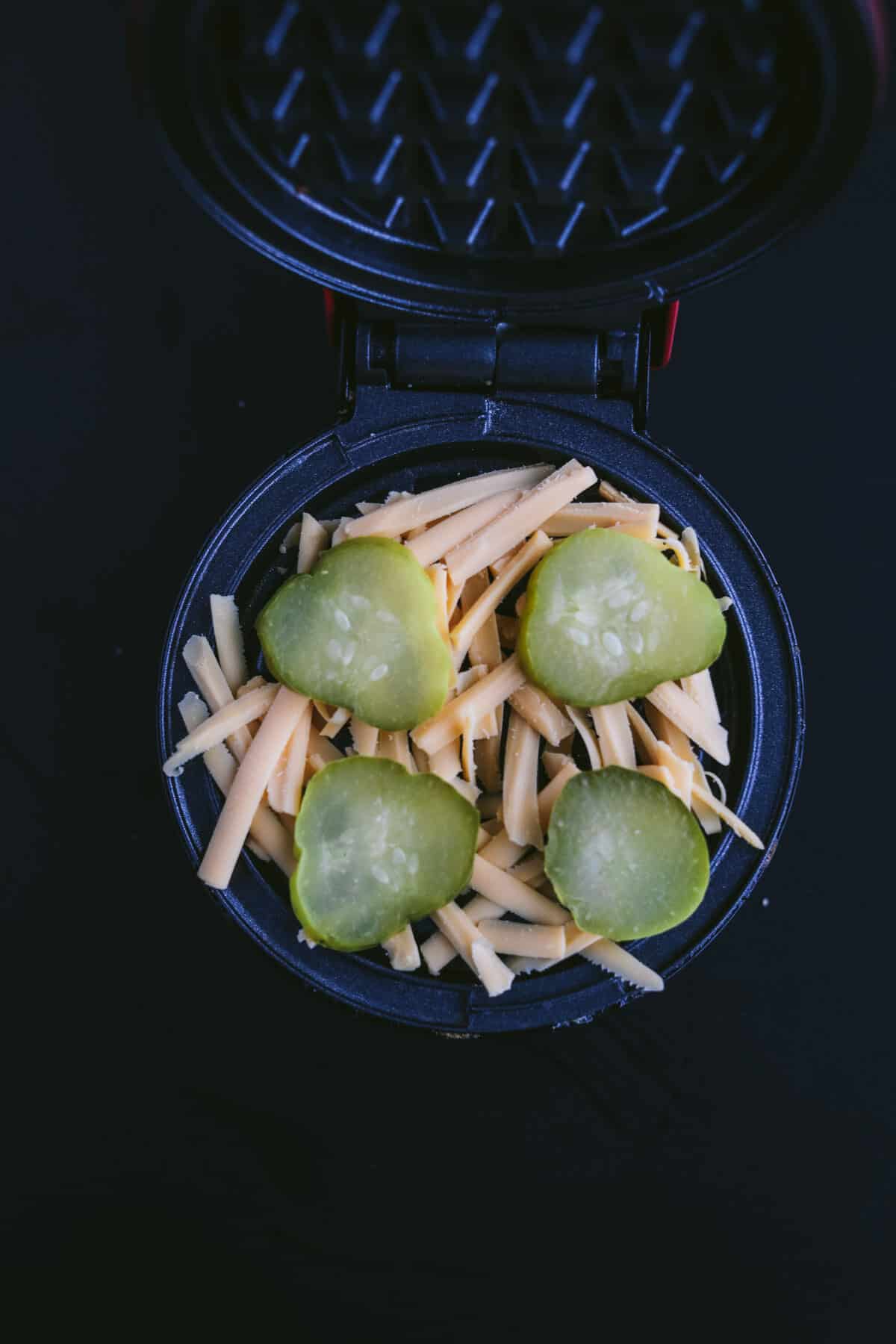 pickles and cheese on a waffle iron